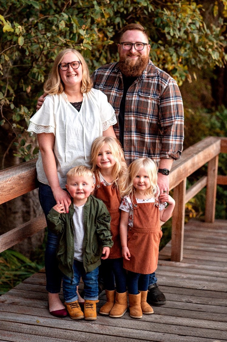 Nate, Taylor, and the kids on a wooden boardwalk in the fall