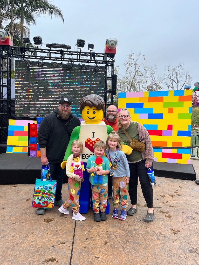 Nate, Taylor, Greg, and the kids posing with a giant LEGO minifigure
